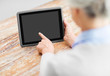 technology and old people concept - senior woman pointing finger to blank screen of tablet pc computer