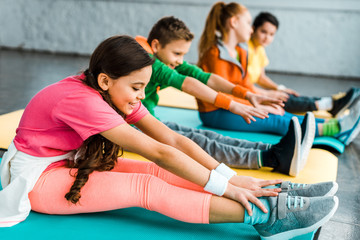 Group of kids stretching in gym together