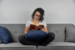 © appledesign - woman reading book on sofa