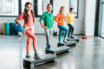 Wall Mural - Group of kids using step platforms in gym