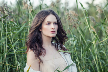 Attractive woman outdoors. Beautiful female model on spring grass background