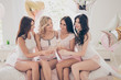 © deagreez - Close up photo four toothy beautiful she her ladies short homey panties sit bed pink white linen sheets clink listening toast balloons colored sleep costumes friends girls day night marriage