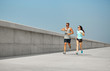 © Syda Productions - fitness, sport and lifestyle concept - happy couple in sports clothes and sunglasses running outdoors
