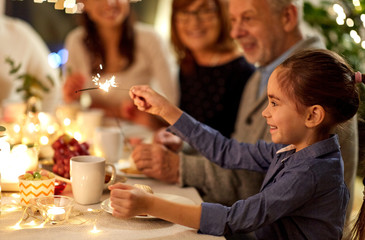 Poster - celebration, holidays and people concept - happy girl with sparkler at family tea party