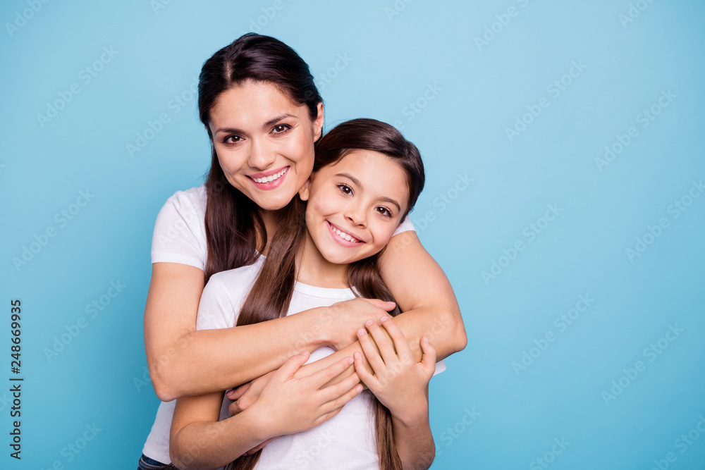 Close up photo amazing pretty two people brown haired mum mom small little daughter stand hugging piggy back lovely free time rejoice wearing white t-shirts isolated on bright blue background - obrazy, fototapety, plakaty 