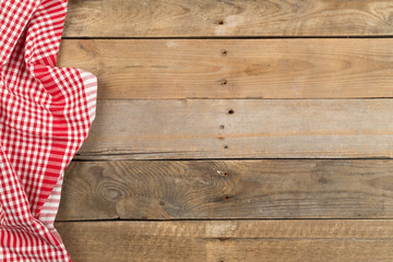 Poster - Red checkered dishcloth on brown rustic wooden plank table flat lay top view from above