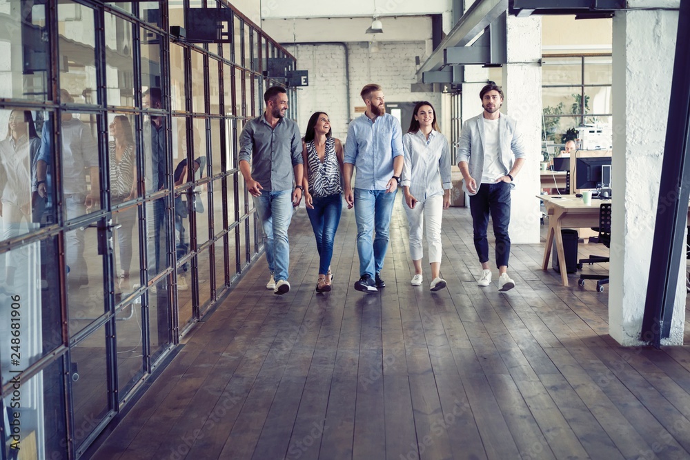 On the way to business meeting. Full length of young modern people in smart casual wear having a discussion while walking through the office. - obrazy, fototapety, plakaty 