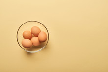 Top View Of Fresh Eggs In Glass Bowl On Yellow Background