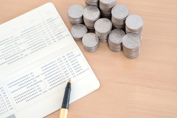  coins and pen on savings account passbook