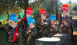 © JackF - Friendly group of children paintball players in camouflage posing with guns on paintball playing field outdoors