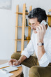 © LIGHTFIELD STUDIOS - senior man talking on smartphone and looking at calculator at home