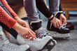 © Fxquadro - Young couple preparing to a skating. Close-up photo of their hands tying shoelaces of ice hockey skates in a locker room