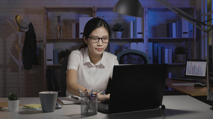 business accounting overwork deadline and people concept. woman worker with tax form calculator and notebook computer working at night office alone. young lady overtime working tired exhausted.