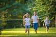 © illustrissima - Boys and girl play and run a race on the lawn outdoor