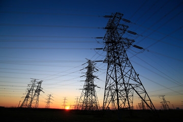 Wall Mural - A high-voltage tower in the setting sun against the sky