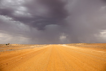 Oodnadatta Track, South Australia; Yellow Dirt Road With Storm Clouds And Horizon