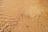 Fototapeta Dmuchawce - Close-up Fine beach sand dunes in the summer sun smooth texture as background. Aerial top drone view