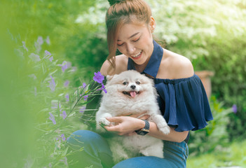 Wall Mural - Woman hug with pomeranian dog in garden