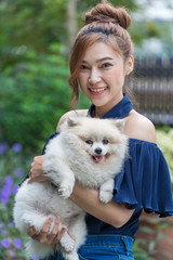 Wall Mural - Woman hug with pomeranian dog in garden