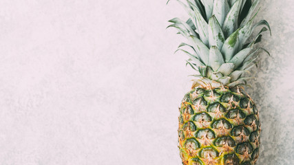 Wall Mural - Ripe pineapple on grey textured background.