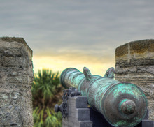 An Aqua Blue Spanish Colonial Cannon On Top Of An Old Spanish Fort, Overseeing A Cloudy Dusky Sky And Palm Trees. Shot In Castillo De San Marcos, St Augustine, Florida, USA.