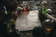 Ancient recipe scroll book and various dry herbs on a table of witch doctor. Herbal medicine essential oil on a table. Witchcraft background with copy space.