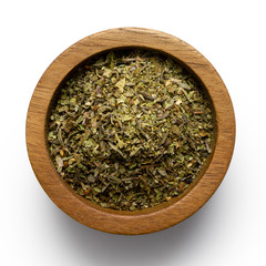 Wall Mural - Dried chopped provence herbs in a dark wood bowl isolated on white from above.