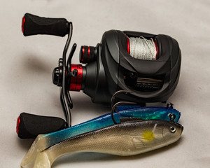 Close up of baitcasting reel with two rubber bass lures