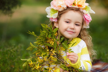 Beautiful little girl outdoors in a blooming spring garden on a sunny day.Little girl in sunny spring. Summer girl fashion. Happy childhood. Springtime. Small child. Natural beauty. Childrens day.