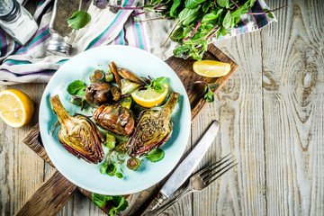 Cooked baked artichoke, alla romana, grilled artichoke flowers with olive oil, lemon, garlic, mint  and spices. Copy space