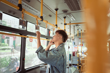 Handsome hipster modern man calling by mobile phone in bus