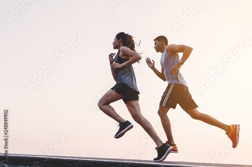 Fotografía young couple runner running on running road in city park
