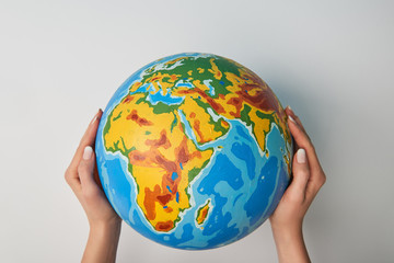 cropped view of woman holding globe on white background