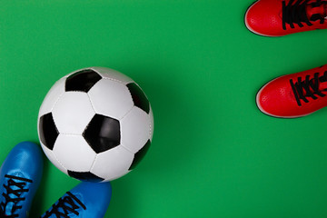 Wall Mural - top view to soccer ball between soccer players feets on green background