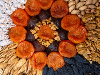 Wall Mural - Dried apricots raisin and nuts , round composition. Circle divided into parts made of a nuts and dried apricots. Concept of healthy snack. Various nuts and dried fruits close up