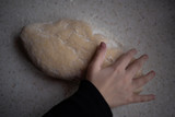 Fototapeta  - Dłoń na cieście surowym posypanym mąką 