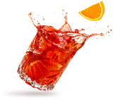 orange slice falling into a splashing negroni tilted on white background
