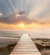 © nicemyphoto - Wood bridge on the sea which has walk way for travel with beautiful sky and sunshine background.