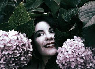 beautiful young woman enjoying among flowers