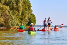 Group Of Friends (people) Travel By Kayaks. Kayaking In Wilderness Of Danube River In Summer. Peacefull Nature Scene Of Calm River. Water Tourism Concept.