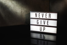 Never Give Up Motivational Message On A Light Box In A Cinematic Moody Background