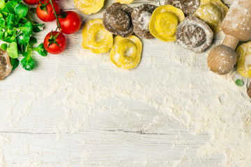 Wall Mural - Homemade fresh Italian ravioli pasta on white wood table  with flour, basil, tomatoes,background,top view.