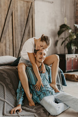 Beautiful couple in love laughs and kisses on the bed