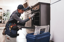 Don't Delay With Repair. Close-up Of Repairman Examining Oven