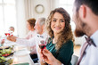 © Halfpoint - A young couple sitting at a table on a indoor birthday party, clinking glasses.