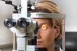 © mmphoto - Augenuntersuchung an der Spaltlampe mit weiblichem Patienten