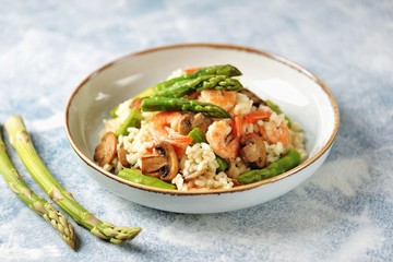 Italian risotto with shrimps, mushrooms, asparagus and parmesan. Healthy food.