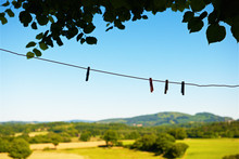 Clothespins On A Wire And Country Background On Summer Afternoon.