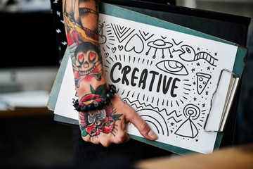 Wall Mural - tattooed hand holding a creative clipboard