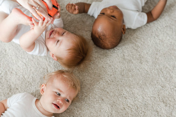 Wall Mural - Cute babies lying on the carpet